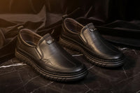 Pair of black leather shoes on a light gray background