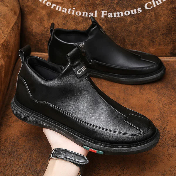 Black leather shoes being worn on a brown surface with 'International Famous Club' text.