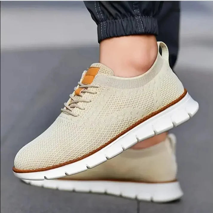 Beige sneaker with white sole worn by a person on a blurred background