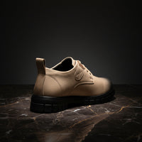 Beige shoe with black sole on a white background