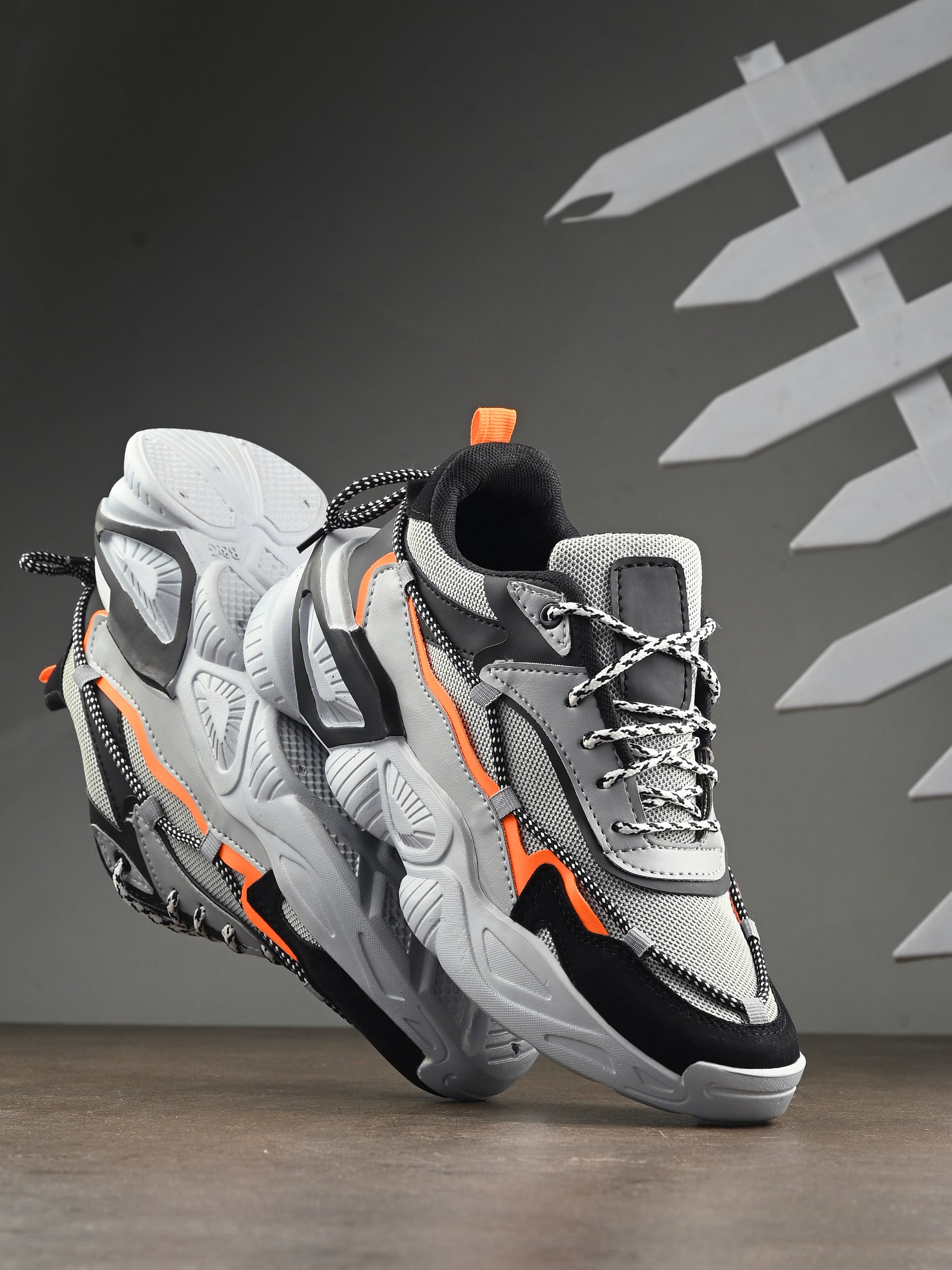 Gray and black sneakers with orange accents on a dark background