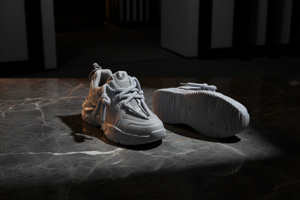 Gray sneakers with white laces on a white background