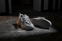 Gray sneakers with white laces on a white background
