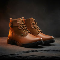Pair of brown leather boots with black soles on a white background