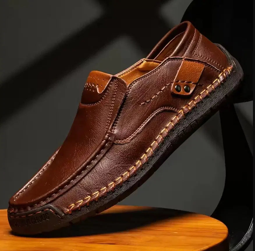 Brown leather shoe on a wooden surface with a dark background