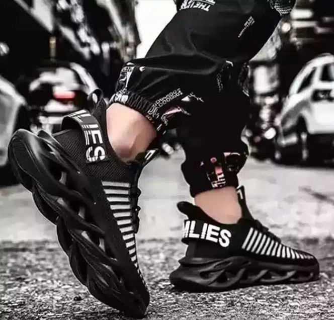 Black sneakers with striped socks worn by a child on a street background